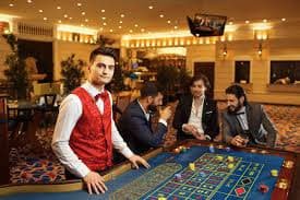 Live Dragon Tiger dealer at kongbet slot studio with multiple camera angles showing card placement